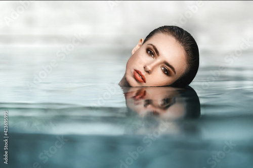 Young pretty fashion woman posing outdoor in summer in bikini on pool