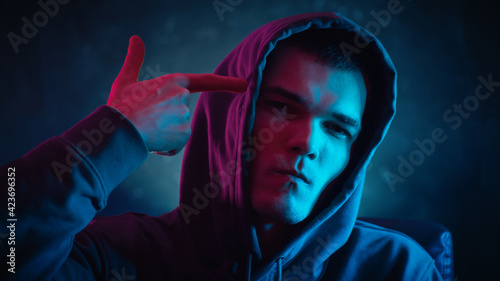 Canvas Print The hipster shoots himself in the head, gesturing with his hand