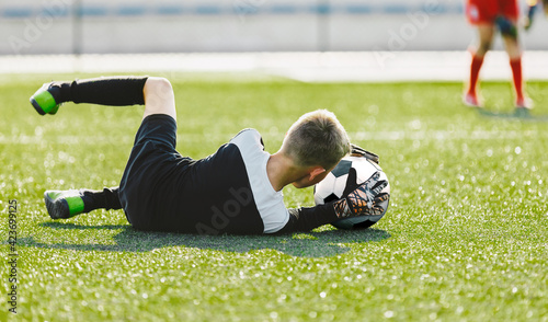 Soccer Goalie Drills. Young Boy as a Soccer Goalkeeper in Action Catching Ball. Football Kid Saving Ball Practice Session. Young Football Goalie Practice Training Saving Drill