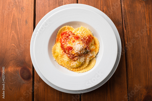 Piatto di ravioli di zafferano ripieni di ricotta con salsa di pomodoro e parmigiano, Cucina Italiana 