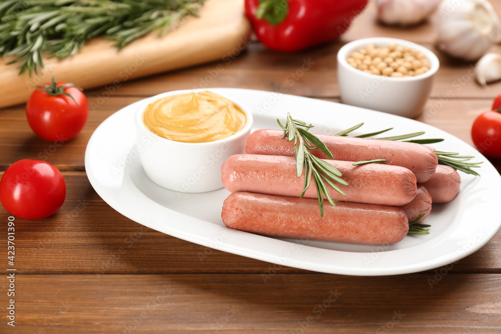 Delicious vegetarian sausages with rosemary and sauce on wooden table Delicious vegetarian sausages with rosemary and sauce on wooden table