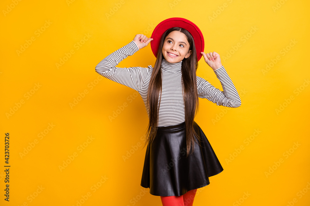 Portrait of attractive cheerful long-haired girl touching hat thinking creating idea isolated over bright yellow color background Portrait of attractive cheerful long-haired girl touching hat thinking creating idea isolated over bright yellow color background