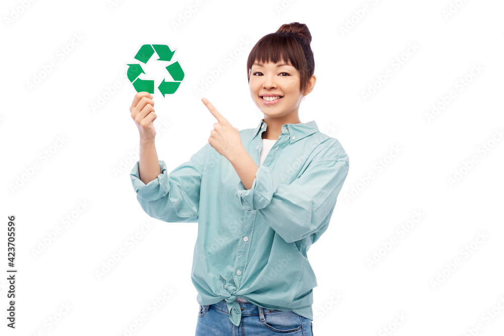 Fototapeta premium eco living, environment and sustainability concept - portrait of happy smiling young asian woman in turquoise shirt holding green recycling sign over grey background