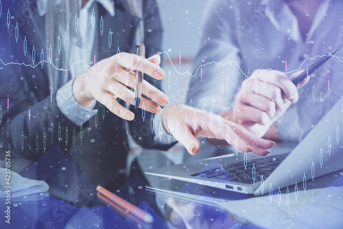 Multi exposure of man and woman working together and financial chart hologram. Business concept. Computer background.