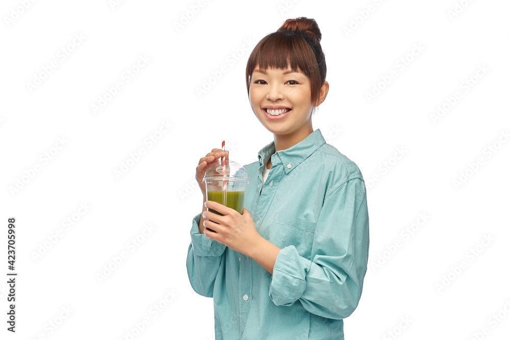 diet, healthy eating and detox concept - happy smiling young asian woman drinking green vegetable juice or smoothie from plastic cup with paper straw over white background diet, healthy eating and detox concept - happy smiling young asian woman drinking green vegetable juice or smoothie from plastic cup with paper straw over white background