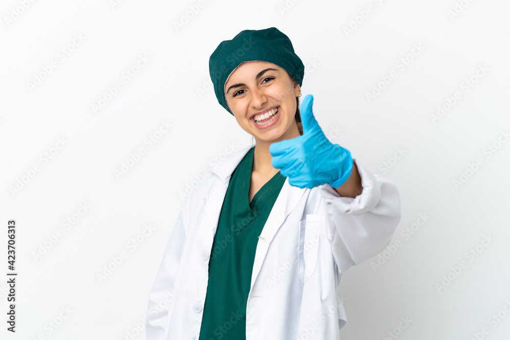 Surgeon caucasian woman isolated on white background with thumbs up because something good has happened Surgeon caucasian woman isolated on white background with thumbs up because something good has happened