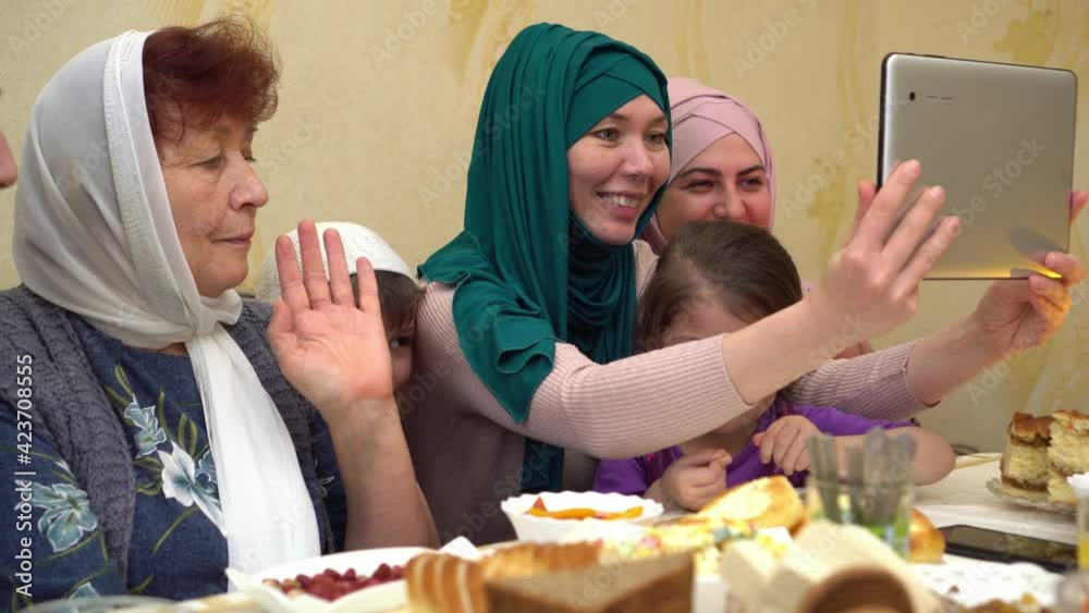 Ramadan holiday online during lockdown. Happy Muslim family make video phone call while iftar dinner at home. Festival of Breaking the Fast Ramadan holiday online during lockdown. Happy Muslim family make video phone call while iftar dinner at home. Festival of Breaking the Fast