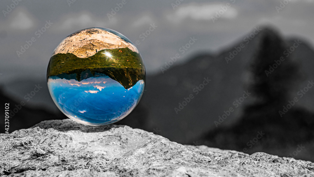Crystal ball alpine landscape shot with black and white background outside the sphere at Zauchensee, Salzburg, Austria Crystal ball alpine landscape shot with black and white background outside the sphere at Zauchensee, Salzburg, Austria