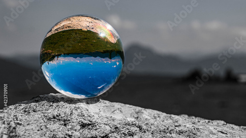 Crystal ball alpine landscape shot with black and white background outside the sphere at Zauchensee, Salzburg, Austria