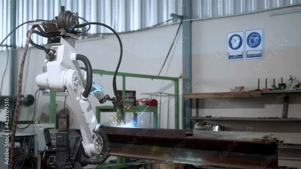 industrial 4.0 concept modern automated robot welding arm machine tool welds metal pipe and plate with bright sparks and smoke in production plant shop factort background industrial 4.0 concept modern automated robot welding arm machine tool welds metal pipe and plate with bright sparks and smoke in production plant shop factort background