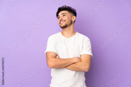 Arabian handsome man over isolated background looking up while smiling