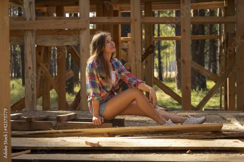 Beautiful girl builds a wooden house