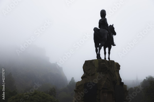 The Royal Scots Greys Monument, an ominous dark presence and equestrian statue over Princes Street Gardens on a misty, foggy day in Edinburgh, Scotland.