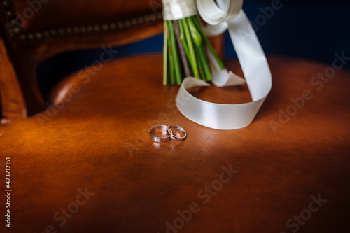 wedding rings lie on a codon chair