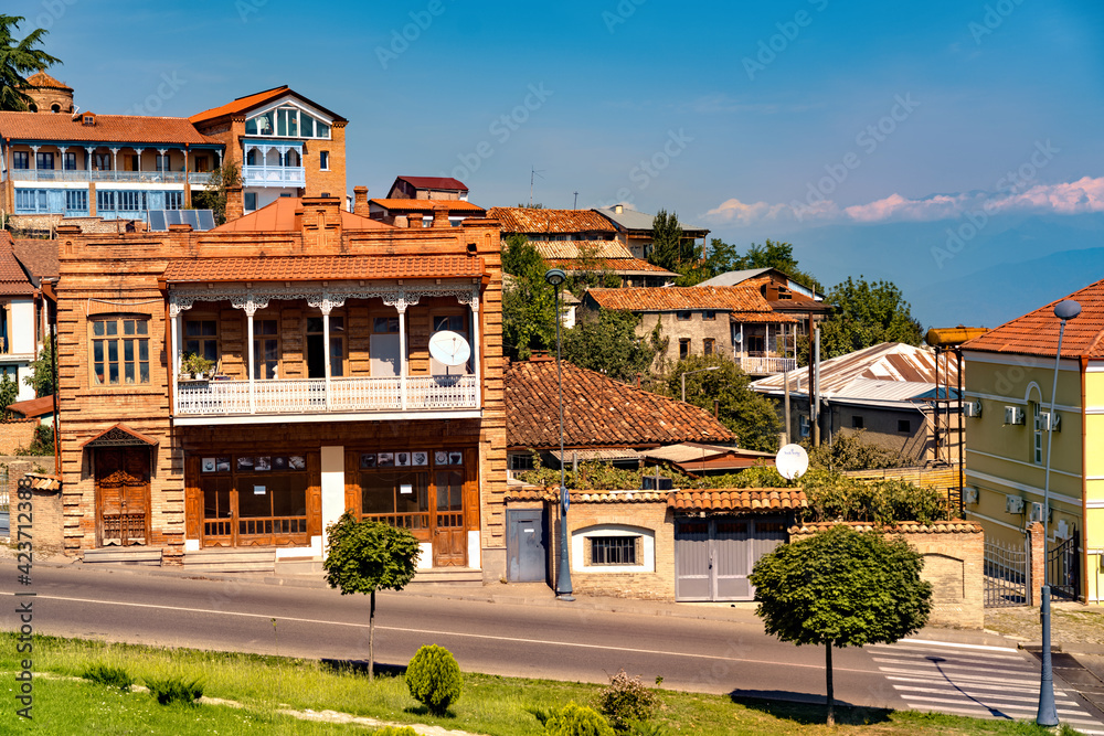 Three-storey brown house with a balcony