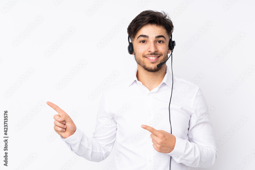 Telemarketer Arabian man working with a headset isolated on white background pointing finger to the side Telemarketer Arabian man working with a headset isolated on white background pointing finger to the side