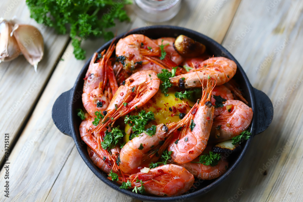 Shrimp in a frying pan. Fried flambé shrimps in shells with spices.