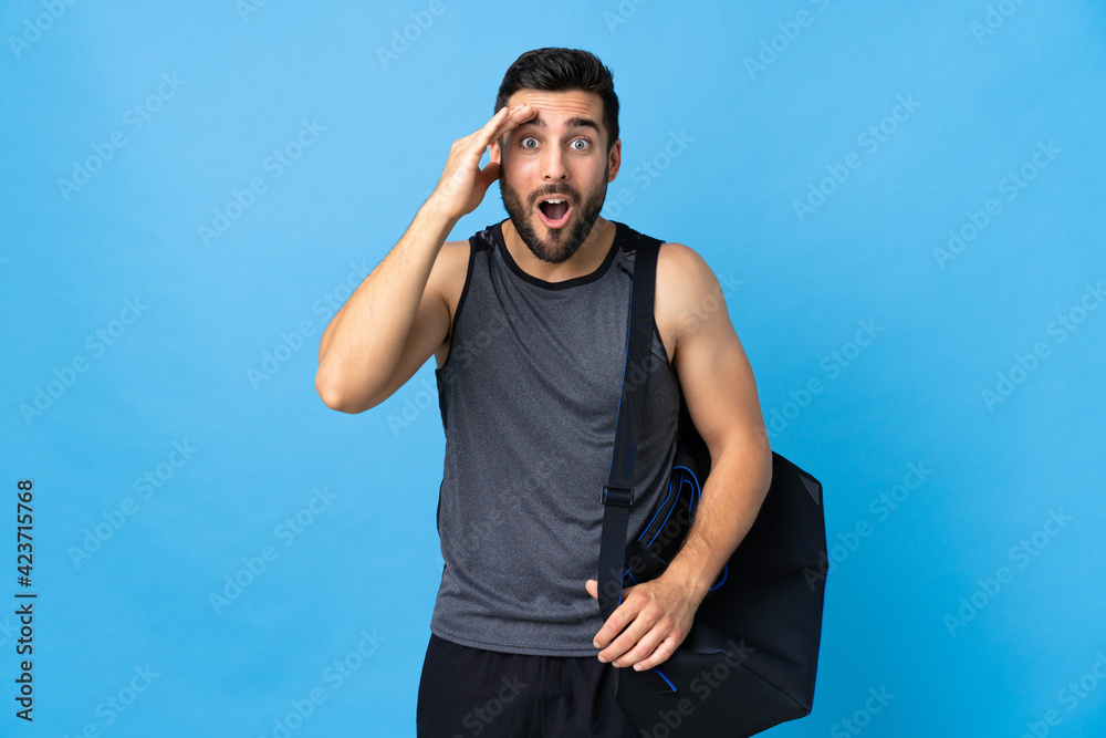 Naklejka premium Young sport man with sport bag isolated on blue background has realized something and intending the solution