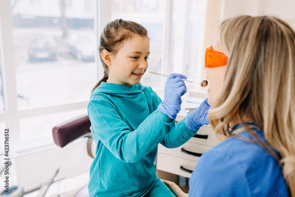 Child stomatologist with a patient at a dental clinic checking teeth. Child stomatologist with a patient at a dental clinic checking teeth.