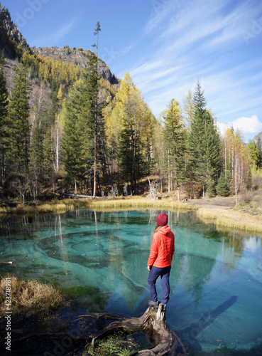 Blue Geyser Lake in Altai Mountains, Siberia, Russia. Woman Looking at the Geyser Lake.