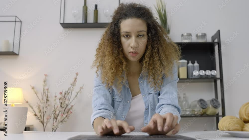 Female freelancer typing on laptop, working remotely from home, journalist