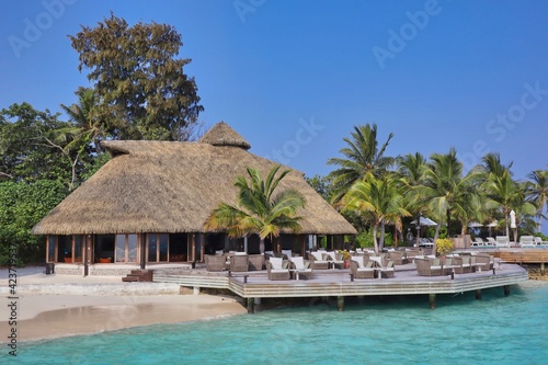 Thatched Bar with Chairs in Maldives with Turquoise Sea and Blue Sky. Maldivian Resort Komandoo.