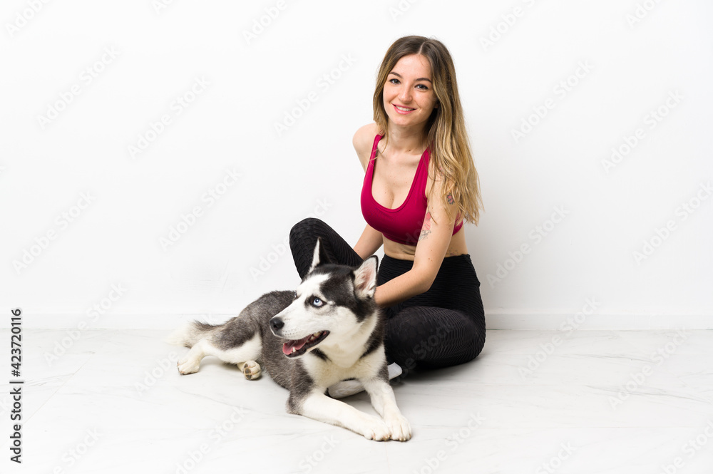 Young sport girl with her dog sitting on the floor