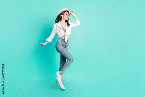 Photo of cute adorable lady wear spectacles arm headwear jumping high looking empty space isolated turquoise color background