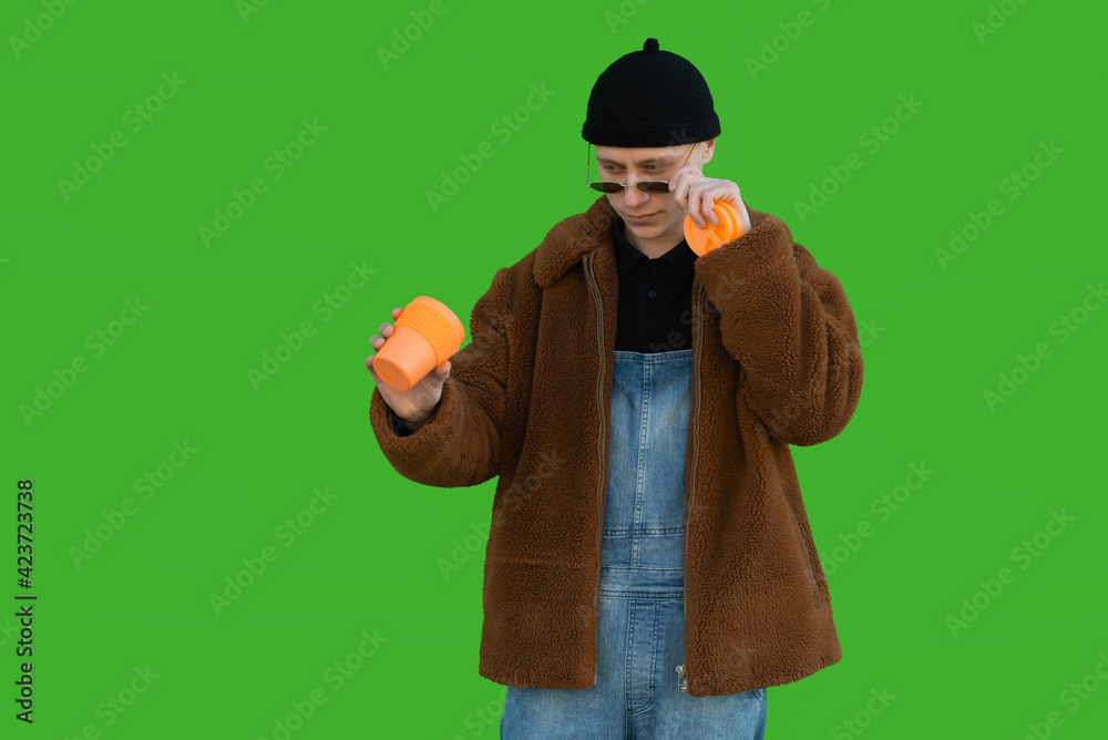 The guy taking off his glasses looks into a cup with a serious expression on his face The guy taking off his glasses looks into a cup with a serious expression on his face