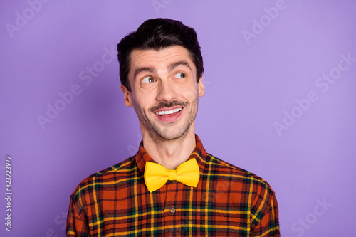 Photo of minded smart guy look empty space think wear bow tie checkered shirt isolated violet background