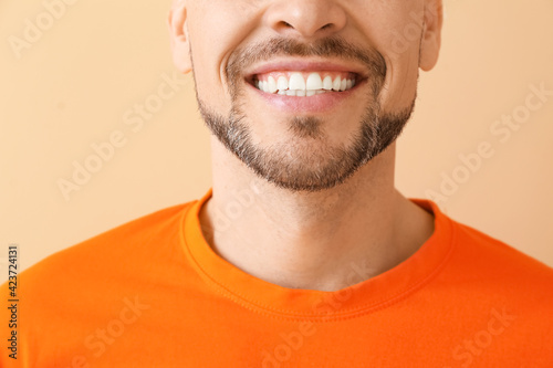 Smiling man on color backgr...