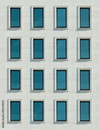 Modern minimalistic facade of the building. Windows on light tiles © Bakulov