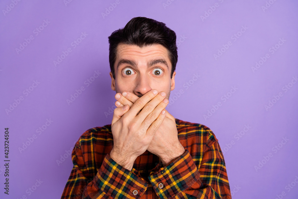 Photo of crazy guy crossed palms cover mouth look camera wear bow tie plaid shirt isolated purple background Photo of crazy guy crossed palms cover mouth look camera wear bow tie plaid shirt isolated purple background