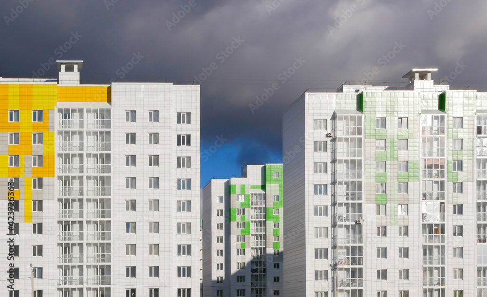 New high-rise apartment buildings against the backdrop of sky and clouds. New residential neighborhood