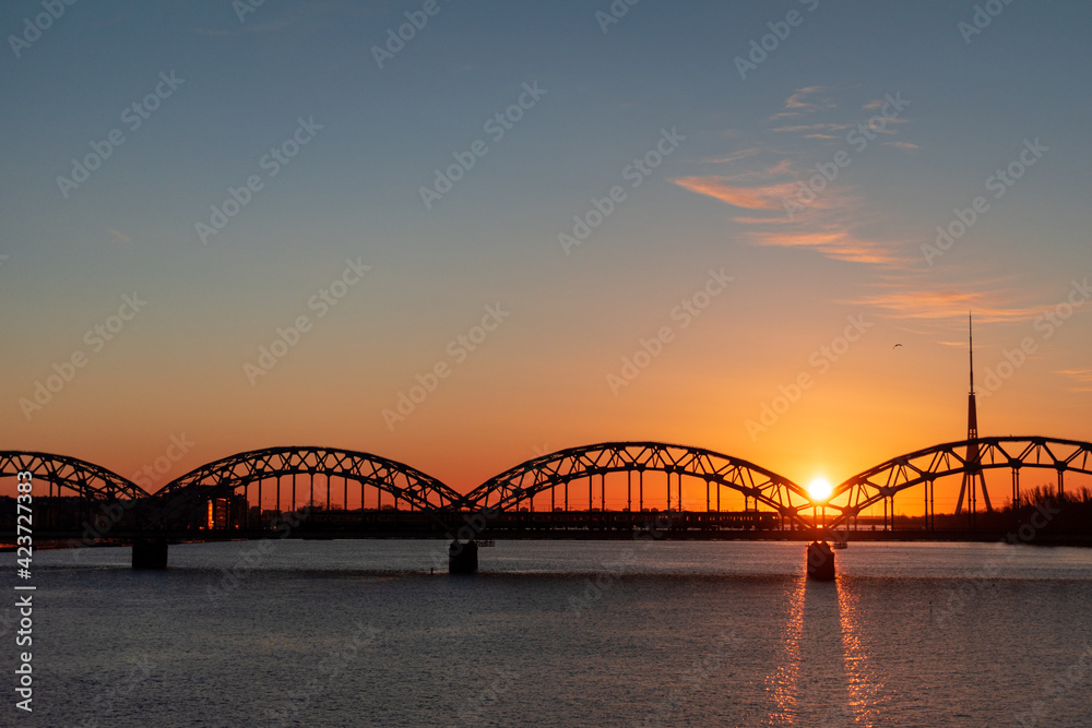 Colorful sunrise over the Daugava river and the Railway bridge with the tallest tower in the European Union - Radio and TV tower in Riga, Latvia