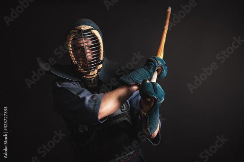 Portrait of Kendo master standing in fighting stance.He practising with shinai.