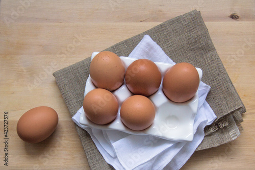 Brown chicken eggs in a stand on a wooden table