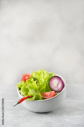 bowl with fresh salad on gray stone background