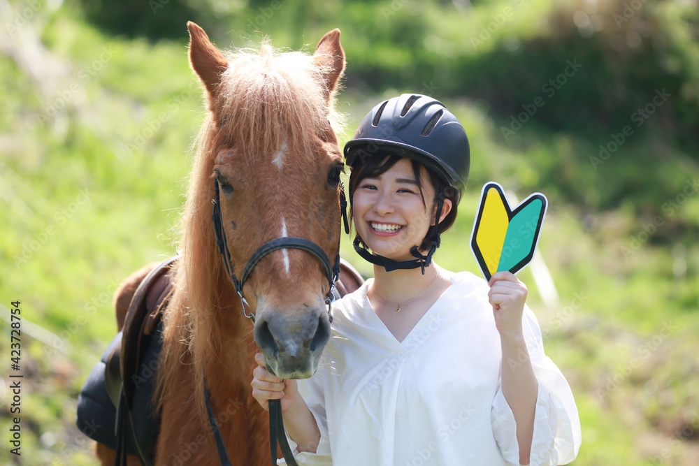 Obraz premium 初心者マークを持つ女性と馬 乗馬イメージ