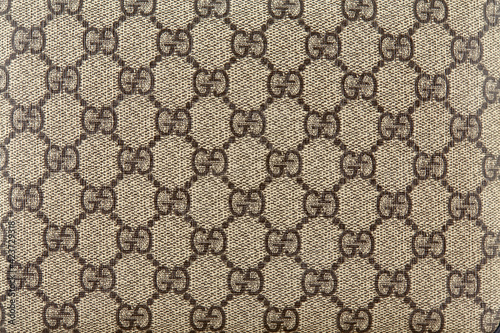Embossed leather, imitating a textile fabric with the Gucci logo arranged  in a checkerboard pattern. Belarus, Minsk, 25.03.2021. Horizontal image.  foto de Stock | Adobe Stock