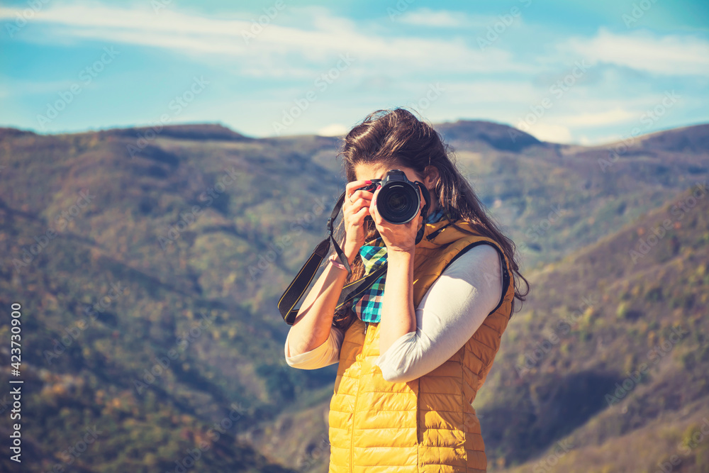 Woman Shooting with Photo Camera in the Mountain .Travel Photographer Taking Photos Outdoor  in the Nature