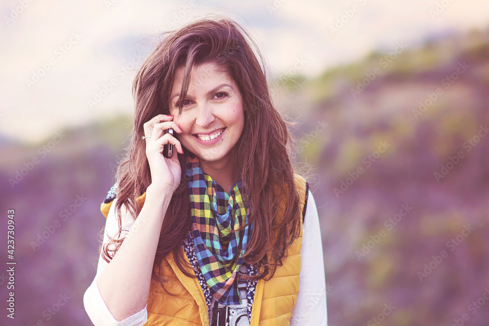 Portrait of Beautiful Smiling  Woman Talking on the Phone Outdoor in the Mountain 