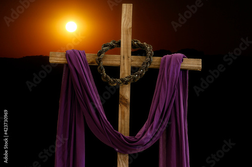 wooden cross, crown of thorns and purple fabric photo