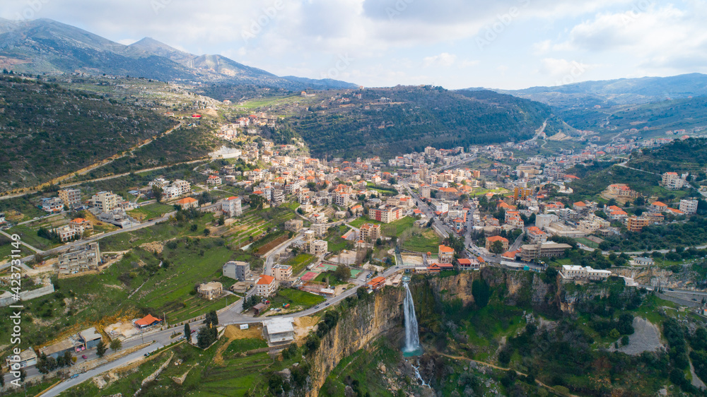 Beautiful village near the forest. Aerial shot of the city and waterfall. The environment. Best hiking trails. Middle East region. Summer season in Lebanon. Cascade
