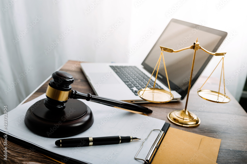 Business and lawyers discussing contract papers with brass scale on desk in office. Law, legal services, advice, justice and law concept picture with film grain effect Business and lawyers discussing contract papers with brass scale on desk in office. Law, legal services, advice, justice and law concept picture with film grain effect