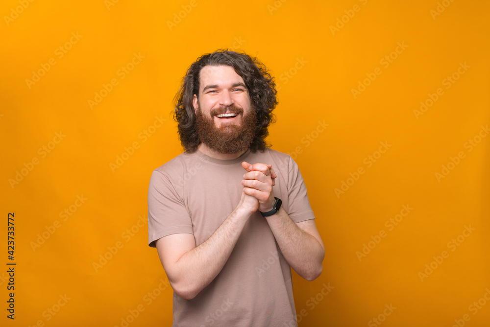 Portrait of cheerful young bearded man with curly hair smiling and looking at the camera Portrait of cheerful young bearded man with curly hair smiling and looking at the camera