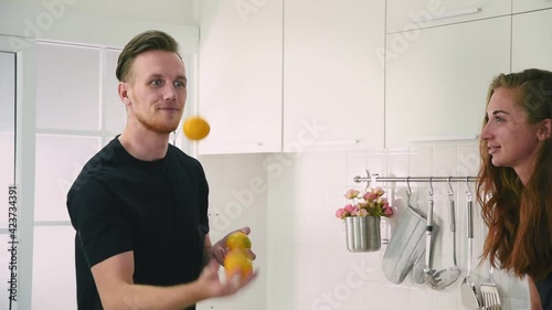 Man and woman couple in casual outfit playing food to impress his girlfriend with happiness and joyful in modern kitchen
