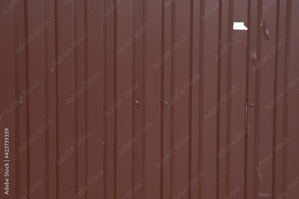 Fototapeta premium Background from a metal fence. Metal brown roof