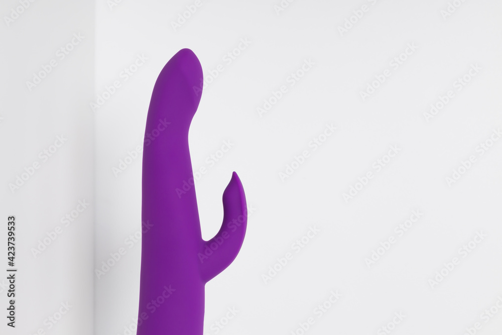Violet dildo on a white background with room for text. Vibrator and masturbation. Sex shop Violet dildo on a white background with room for text. Vibrator and masturbation. Sex shop