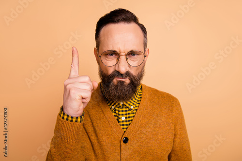 Photo of aggressive strict man frown raise finger wear eyewear brown cardigan isolated beige color background photo